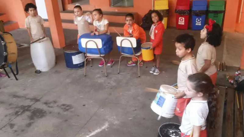 Crianças aprendem tocar instrumentos com produtos reciclados