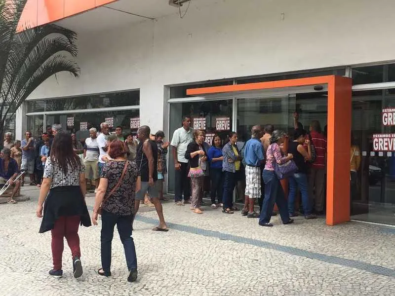 Cidadãos sofrem com as longas filas nas agências báncarias.