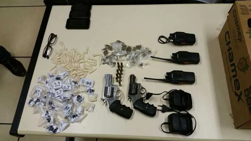 Os PMs apreenderam dois revólveres, três rádios, três celulares, maconha, cocaína e munições