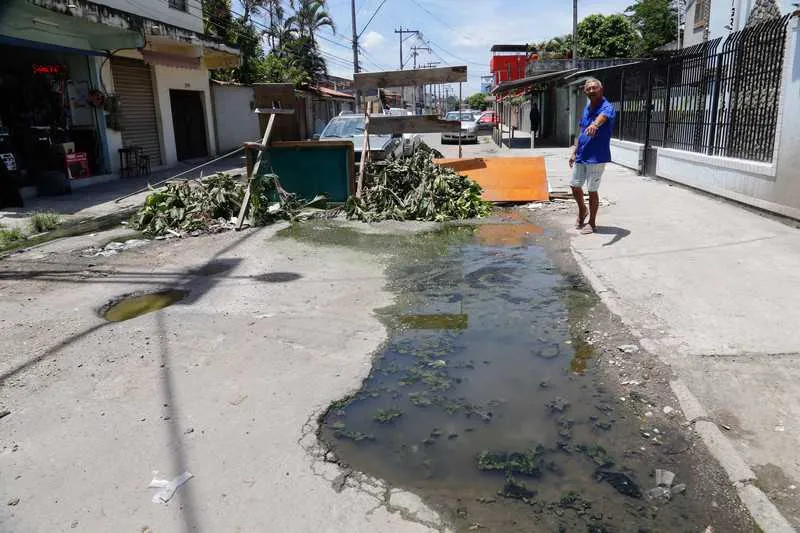 Para evitar o tráfego de ônibus pela via esburacada, moradores interditaram a via com barreiras