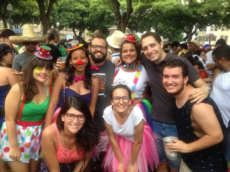 Juliana, caracterizada com nariz e roupa de palhaço, com seus amigos em um bloco do Rio