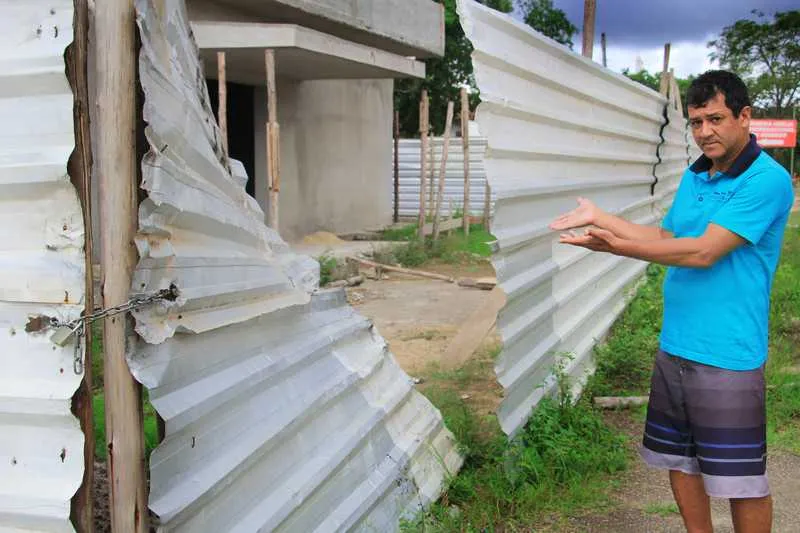 Moradores mostram o estado da construção, que só está com a estrutura de alvenaria pronta