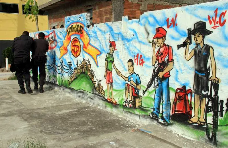 Caricaturas de Máscara e de seus ‘soldados’, armados com fuzis e pistolas, foram feitas nos muros das casas em Santa Luzia
