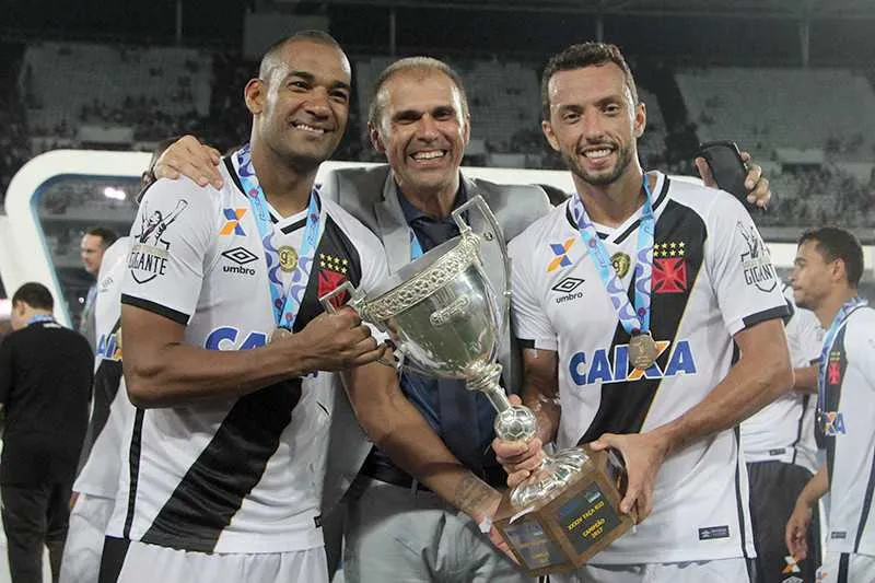 O técnico Milton Mendes segurou a taça ao lado do zagueiro Rodrigo e o meia Nenê