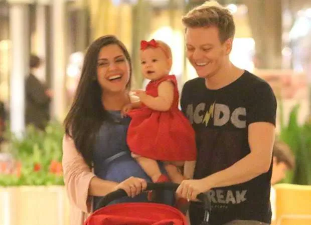 Michel Teló aproveitou a folga na agenda para passear com a filhota Melinda, de 10 meses, e a esposa, a atriz Thaís Fersoza. De vestido vermelho, a pequena roubou a cena num shopping no Rio. Na véspera do "Dia das Mães", Thaís revelou nas redes sociais o nome do segundo herdeiro, que deve nascer próximo do aniversário da irmã, em 1º de agosto: Theodoro! "Que benção poder ter meus pequenos comigo.. não podia ser melhor, não podia ser mais mágico... uma no colo e um no ventre!", escreveu. 