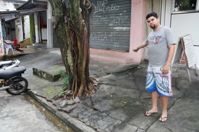 Guilherme mostra como a raiz está levantando a calçada