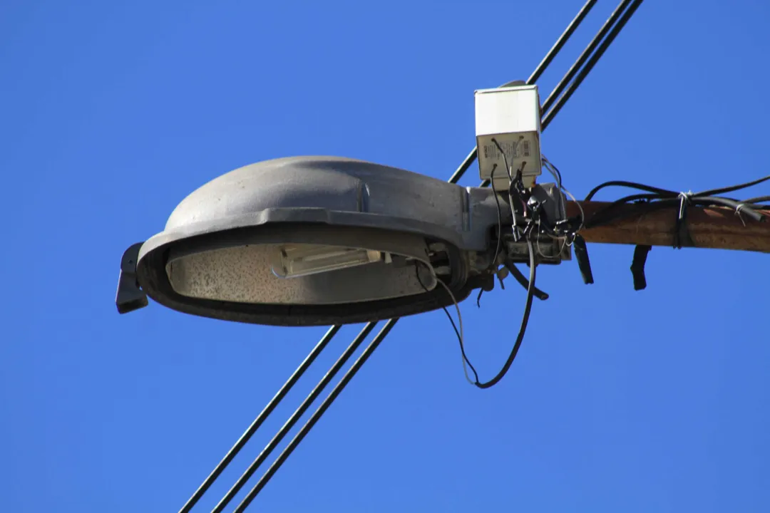 Carlos mostra um dos postes que está com a lâmpada queimada