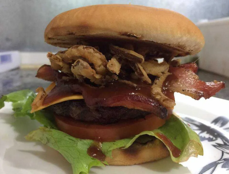 Essa é a proposta do sanduíche Vaca Solidária, que estará no cardápio da Vaca Louca Hamburgueria Gourmet só até esse sábado (29). O sandubão custa R$ 16, e todo o lucro com a venda dessa delícia será encaminhado para ajudar um aposentado que luta contra um câncer. Só a proposta social já deveria abrir nosso apetite, mas esse “monstro” é feito com 100 gramas de carne bovina, queijo cheddar, bacon rústico, cebola crispy, alface, tomate, tudo isso vem coberto por um molho guava barbecue e dentro de um delicioso pão careca, selado no azeite de ervas. A combinação ficou sensacional, e você pode juntar sua fome com a vontade de ajudar ao próximo.A hamburgueria trabalha somente com entregas e funciona de quarta a sábado.
Facebook - Vaca Louca Hamburgueria Gourmet