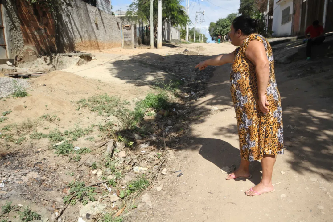 Moradora mostra a situação precária da Rua 3, que não tem iluminação, nem pavimentação