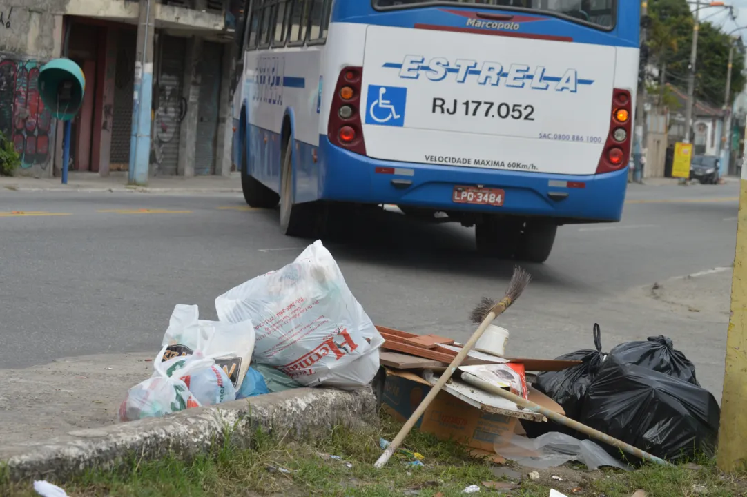 Sacos de lixo ficam acumulados em rua principal do bairro
