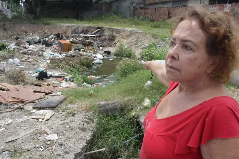  A dona de casa Hozana Brun mostra o lixo jogado no terreno