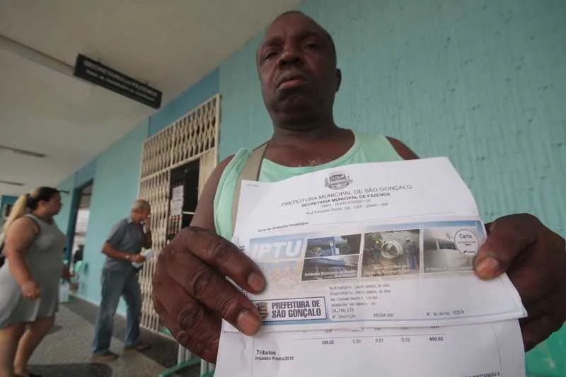 O gari Carlos Gabriel da Cruz reclama do valor cobrado e das péssimas condições da rua onde mora