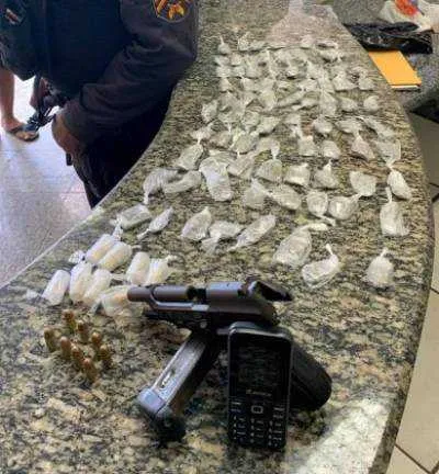 Durante a revista, os agentes encontraram uma pistola calibre 380 com oito munições intactas, 78 tabletes de maconha e oito pinos de cocaína