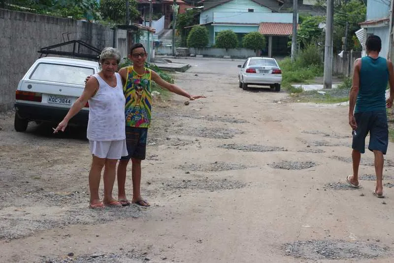 >> Moradores compraram pedras para tapar os buracos da rua