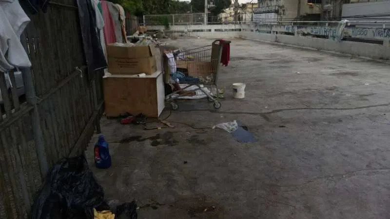 >> Uma mulher, que vive no local com o marido, disse que eles moram na rua por falta de trabalho