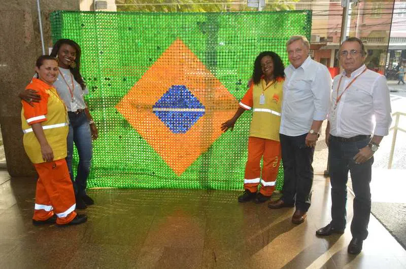 Tampinhas, unidas pelo quase invisível fio de nylon, viraram uma enorme bandeira do Brasil