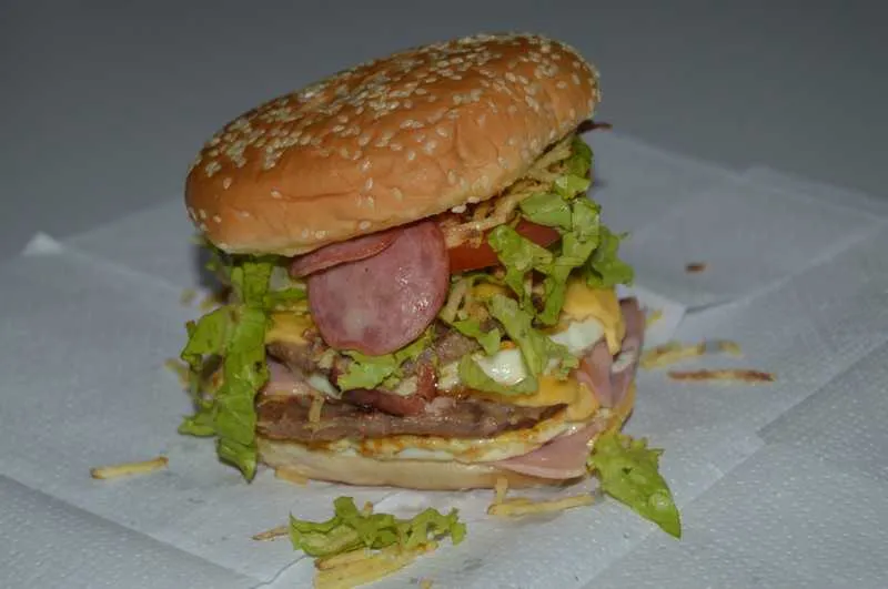 ‘Monstro’ de
hambúrguer

O tradicional X-Tudo que a gente ama de um jeito muito melhor. É difícil imaginar, né? Mas a família que comanda a lanchonete ‘Cheio de Fome’, em Neves, São Gonçalo, deu um jeito para isso acontecer. Mas se prepare, pois é necessário realmente estar com bastante fome, pois o ‘sanduba’ que leva o nome da empresa é um x-tudo triplicado. Três carnes, três fatias de queijos, três fatias de presunto, três ovos, bacon, calabresa, cheddar, catupiry, muita batata palha e uma saladinha. O hambúrguer é gigante! Vale a pena ficar faminto e pedir esse ‘monstro’. O local faz entrega em diversos pontos de São Gonçalo. Confira em: facebook.com/lanchonetecheiodefome/.

