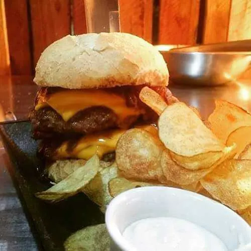 Criatividade e sabor em forma de sanduíches
Pão de sal fresquinho e macio é irresistível, não é? Agora imagina esse pão, com dois blends de fraldinha com bacon, de 160 gramas cada um, coberto com queijo cheddar, bacon crocante e cebola caramelizada no vinho. Babou aí? Tem mais... acrescente a porção de batata chips, servida quentinha e crocante! Amigos, o pessoal do Premium Garage entende de perfeição e o sanduda “Big Brasília” se encaixa nesse adjetivo. O hambúrguer é suculento, a carne tem a crosta da fritura por fora e se mantém macia por dentro e é servida ao ponto. Os lanches de pão francês têm aquela cara de sanduíche caseiro feito por uma boa cozinheira de mão cheia. A “garage” dos caras está lotada de hambúrgueres, que levam nomes de grandes veículos. Dá uma conferida nos detalhes em: facebook.com/premiumgaragesg/

