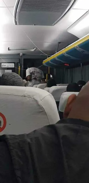 Criminoso aparece perto da porta do ônibus, de costas