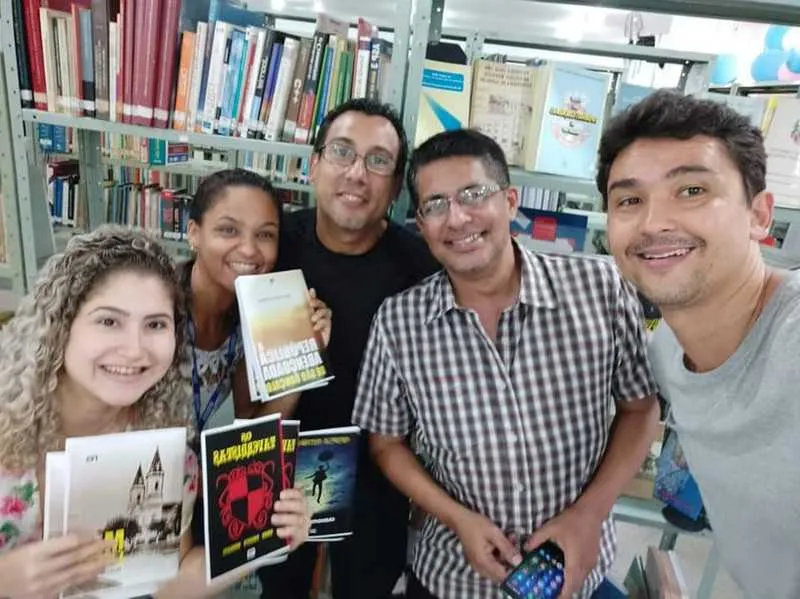 Em 2019, bibliotecárias receberam Helcio (com camisa xadrez) e os autores da AB, Erick Bernardes e Mario Lima Jr, que doaram livros para a Biblioteca Municipal Genebaldo Rosas, no Mutondo